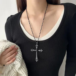 Detailed view of a vintage punk cross necklace on model with black beaded chain