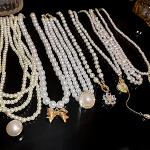Detail view of various faux pearl necklaces with elegant heart and flower pendants