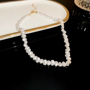 Close-up of elegant irregular baroque pearl necklace with high-end luster on black background