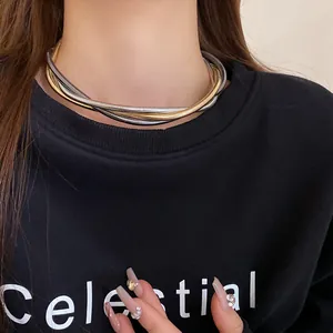 Macro detail of a layered gold and silver mixed metal entwined choker necklace.