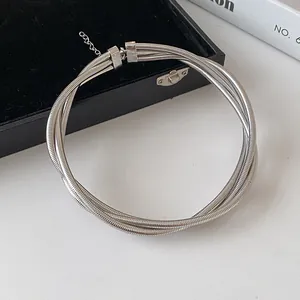Close-up of silver multi-layer snake chain necklace in minimalist metal style