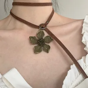 Macro detail of vintage punk metal flower pendant with embossed leather strap choker necklace