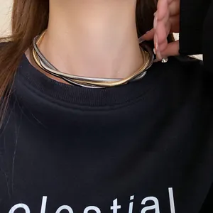 Detail shot of a multi-strand twisted metallic snake chain necklace on a female model.
