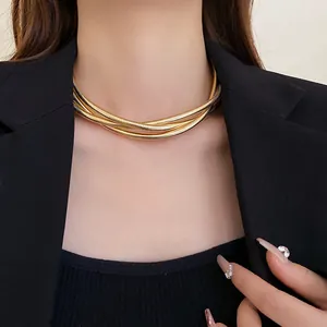 Detail view of a multi-layer gold snake chain choker necklace worn with a black blazer