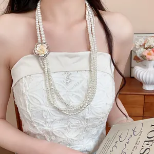 Detail view of a French vintage multi-strand pearl necklace with rhinestone flower.
