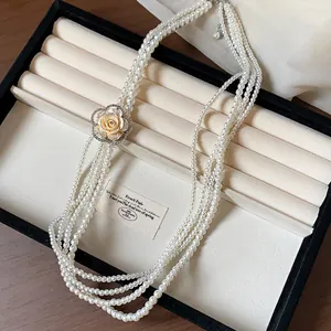 Close-up of elegant multi-strand pearl necklace with a vintage rhinestone rose flower clasp