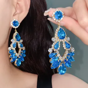 Detail of ornate blue rhinestone water-drop earrings with silver needle in vintage style