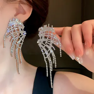 Macro shot of dazzling irregular rhinestone fringe earrings with silver needle studs.