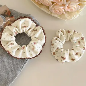 Detailed close-up of sweet Korean style floral and bear pattern scrunchies with lace trim