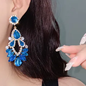 Close-up of luxury blue teardrop rhinestone dangle earrings with elegant gold finish