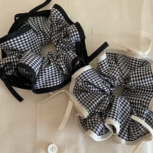 Close-up of elegant black and white gingham scrunchies with stylish ribbon bow ties