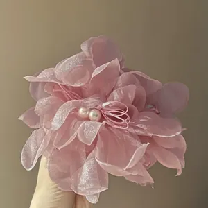 Detailed view of elegant pink 3D fabric flower hair claw clip featuring pearl accents