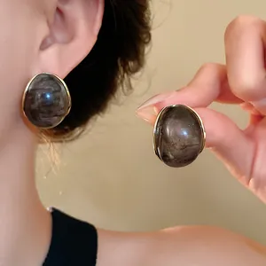 Primer plano de pendientes de resina geométrica vintage con un patrón de mármol