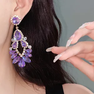 Close-up detail of purple teardrop crystal earrings in vintage court style for elegant look