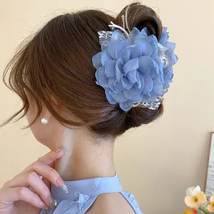 Detailed view of a blue organza flower hair claw clip with delicate pearl accents