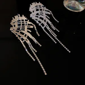 Macro view of irregular tassel earrings featuring shiny rhinestones and silver needles