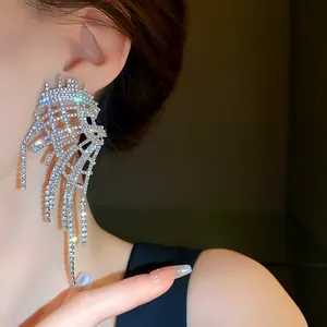 Close-up of exaggerated rhinestone tassel earring worn on ear with sparkling details