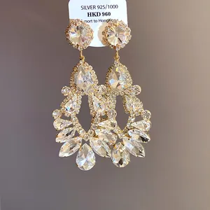 Macro view of gold-toned Baroque teardrop earrings with shimmering faceted crystals