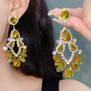 Close-up of luxury waterdrop earrings with green rhinestones and hollow geometric design
