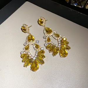 Detailed view of yellow teardrop crystal earrings with elegant hollow geometric design