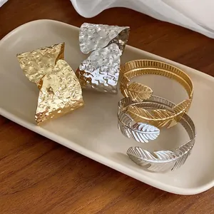 Brazaletes abiertos minimalistas con diseño irregular y de hojas en acabado oro y plata