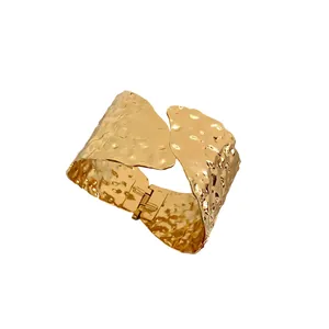 Elegante brazalete dorado con textura martillada y apertura geométrica irregular