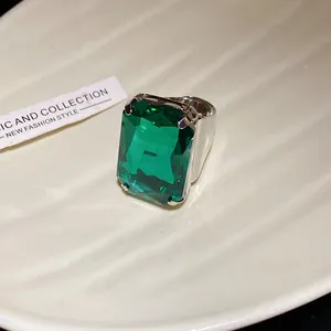 Vista macro di un anello vintage di lusso con pietra verde taglio smeraldo, argentato.