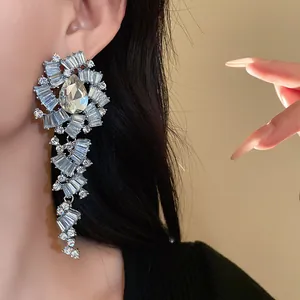 Macrodetail van oversized strass-waterdruppel hangende oorbellen aan het oor