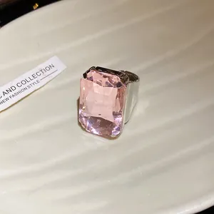 Vista macro dettagliata di un lussuoso anello rosa con taglio a smeraldo su ceramica bianca