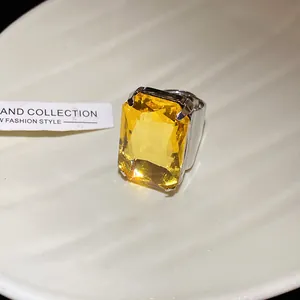 Primo piano di un anello vintage con gemma gialla quadrata e fascia regolabile color argento