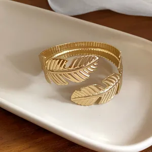 Vista de primer plano mostrando los detalles de la pluma en este brazalete dorado