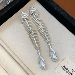 Elegant silver-toned fishbone drop earrings featuring teardrop pearls and zircons