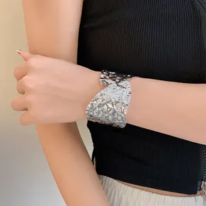 Vista detallada de un brazalete plateado con una textura martillada muy singular.