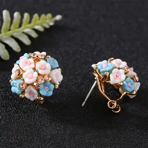 Vue détaillée des boucles d'oreilles en fleurs de céramique avec strass étincelants