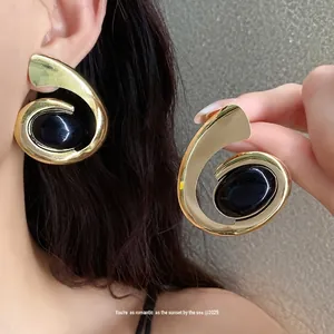Elegante grote gouden geometrische spiraal oorbellen met gepolijste zwarte ovale steen