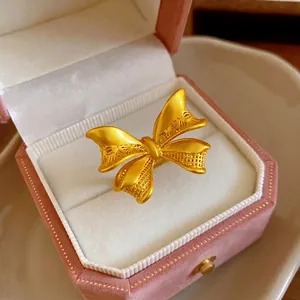 Eleganter mattgoldener Schleifenring in einer rosa Samtschmuckschachtel