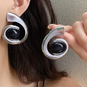 Gedurfde geometrische spiraal oorbellen in zilver en zwart, niche minimalistisch ontwerp.