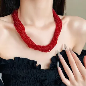 Red multi-strand beaded choker necklace with magnetic clasp worn by a model in black top