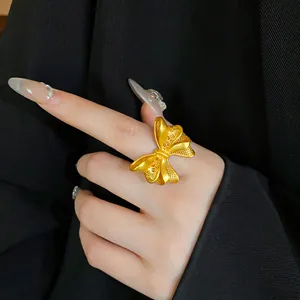 Detaillierte Nahaufnahme eines goldfarbenen Schleifenrings mit feinen Ätzmustern.