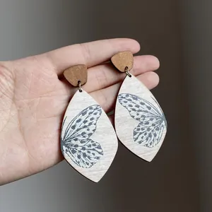 Detailed view of bohemian teardrop wood earrings with intricate butterfly wing prints
