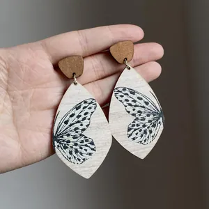 Detailed shot of bohemian style wooden teardrop earrings with butterfly wing prints