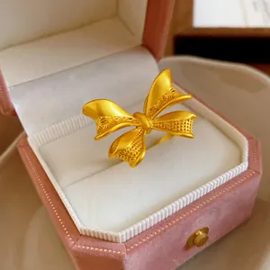 Nahaufnahme eines goldenen Schleifenrings mit filigranen Mustern auf den Flügeln
