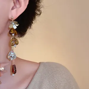 Detail shot showing vintage asymmetric flower tassel earrings with amber heart glass charms