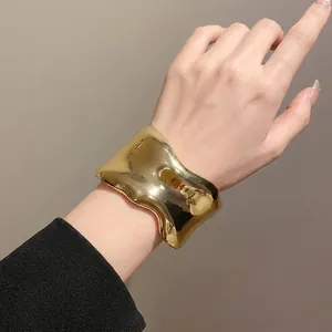 Elegante brazalete de metal dorado irregular y ondulado para moda minimalista de lujo.