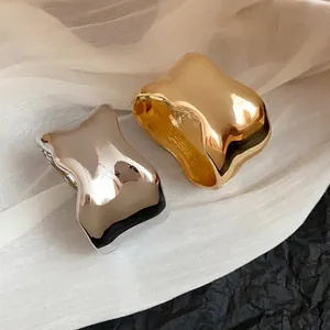 Elegantes brazaletes metálicos ondulados irregulares en acabados oro y plata brillantes