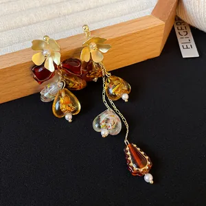 Close-up detail of vintage amber heart and flower tassel earrings with a golden finish