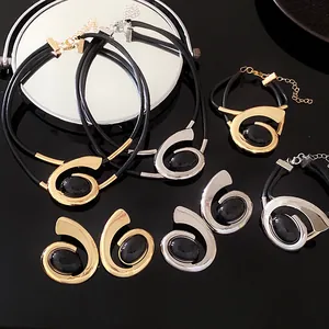 Gedetailleerde weergave van geometrische spiraalvormige sieradensets in goud en zilver met stenen.
