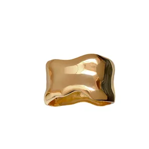 Elegante brazalete de metal dorado irregular con diseño ondulado y acabado brillo