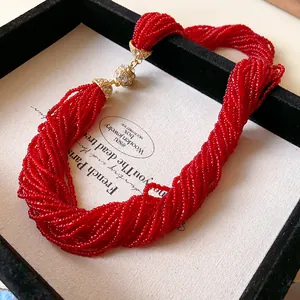 Close-up of red multi-strand beaded necklace with rhinestone magnetic clasp