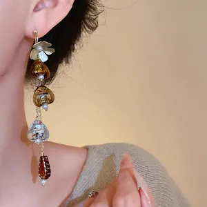 Close-up of asymmetric flower fringe earring in Maillard retro style worn by model